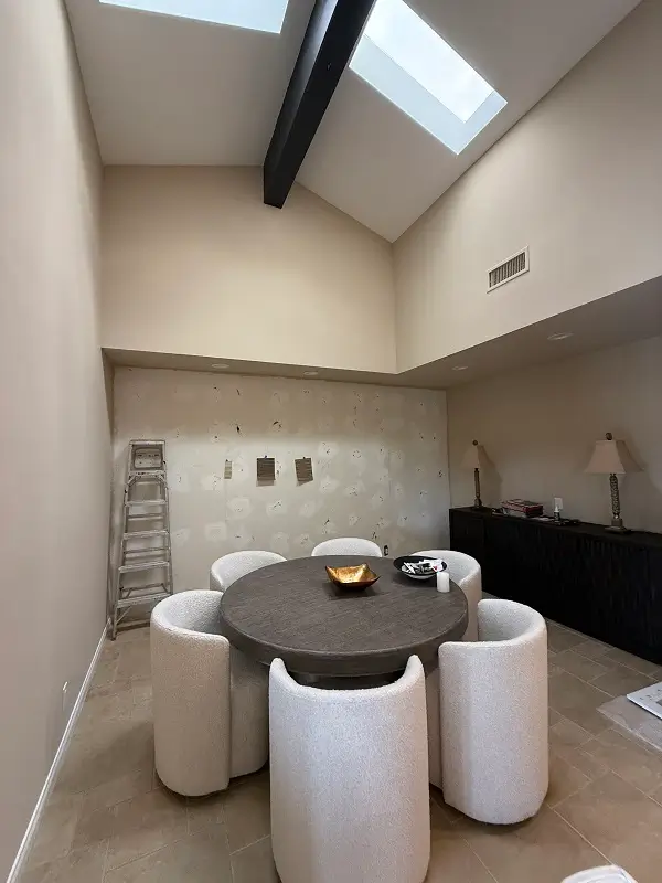 Well lit kitchen dining area with tile floor and high ceiling.