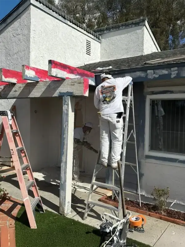 Painter painting the front of a two story home.